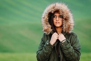 Retrato de una mujer que siente frío en invierno en la pradera verde foto