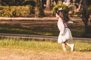 little girl running in a park photo