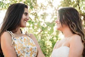 two young women friends in the forest with trees in the background photo