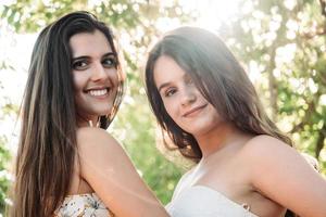 two young women friends in the forest with trees in the background photo