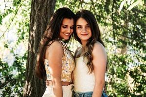 two young women friends in the forest with trees in the background photo