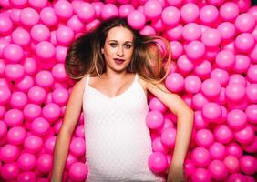 Young pregnant woman playing in a pink ball pool