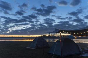 tienda de campaña en el amanecer de la mañana en la orilla del lago foto