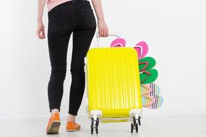 girl with suitcase isolated on white background .Summer holidays. summer flip flops or slippers. Travel valise or bag. Mock up. Copy space. Template. Blank. photo