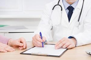 Doctor and patient are discussing something, just hands at the table, medical insurance. photo