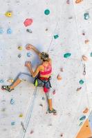 una mujer está escalando un muro de escalada foto