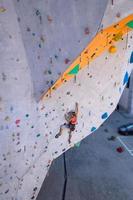 una mujer está escalando un muro de escalada foto