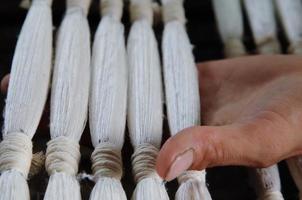 weaving and manufacturing of yarn closeup. the hand holds ready-made yarn photo