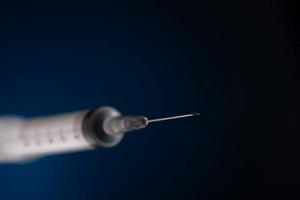 one medical syringe on a dark blue background photo