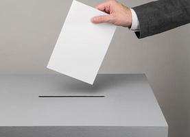 Gray ballot box. Presidential and parliamentary elections. The voter throws the ballot into the ballot box. photo