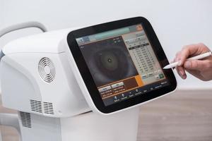 the doctor controls the oculist display with a scanned eye. diagnostic ophthalmologic equipment. medicine concept photo