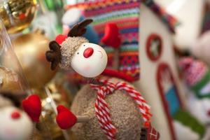 soft toy Christmas deer with a scarf on the background of the house photo