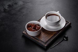 Sweet delicious sweets in the form of chocolate hearts in a white saucer photo