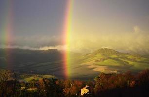 rainbow over tuscanian landscape photo