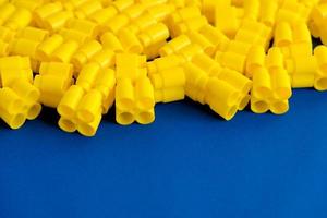 Yellow plastic building blocks on a blue background photo