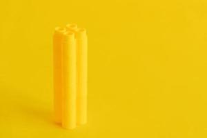 bloques de construcción de plástico amarillo en forma de torre sobre fondo amarillo. Fondo de bloques de construcción de detalles de plástico.