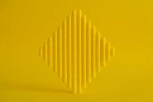 Yellow plastic building blocks in the shape of a cube on yellow background photo
