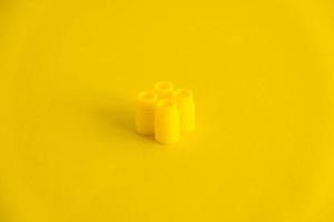 Bloque de construcción de plástico amarillo sobre fondo amarillo. Fondo de bloque de construcción de detalle de plástico foto