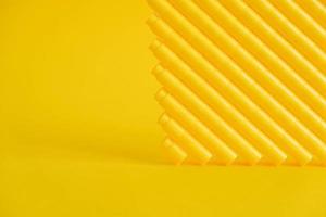 Yellow plastic building blocks in the shape of a pyramid on yellow background photo