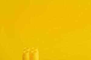 Yellow plastic building block on yellow background photo