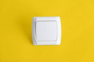 White electro switch on yellow background photo