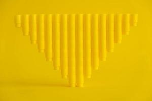 Bloques de construcción de plástico amarillo en forma de pirámide sobre fondo amarillo foto