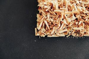 Wood shavings on black background. Background of fresh wood shavings photo