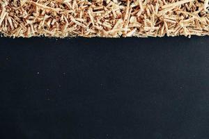 Wood shavings on black background. Background of fresh wood shavings photo