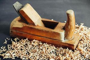 Old hand plane and wood shavings on black background. Old woodworking hand too on a black background photo