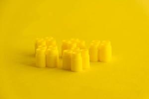 Yellow plastic building blocks on yellow background photo