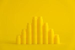 Yellow plastic building blocks in shape of a pyramid on yellow background photo