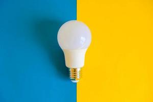 LED light bulb on blue and yellow background photo