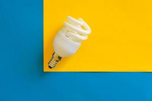 LED light bulb on blue and yellow background photo