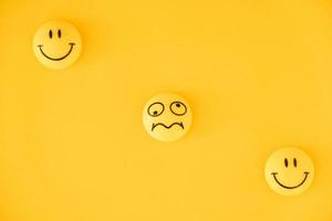 Emoticon icons funny faces on yellow background photo