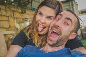 pareja joven disfrutando juntos en el patio trasero. Están sonriendo, riendo y haciendo muecas juntos. foto