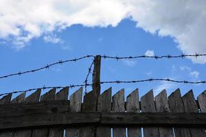 Fence with barbed wire. Caution, danger area. Forbidden fence against the sky. photo