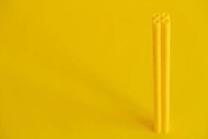 Yellow plastic building blocks in the shape of a tower on yellow background. Background of plastic details building blocks photo
