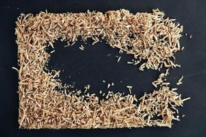 Wood shavings on black background. Background of fresh wood shavings. Copy, empty space for text photo