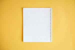 Cuaderno en blanco para escribir sobre fondo amarillo foto