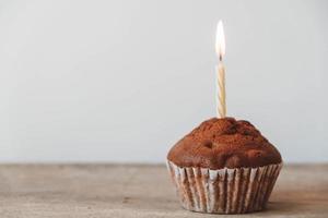 Cupcake de chocolate con velas en la mesa de madera foto