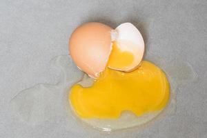 Egg drop crack splattered down on ceramic tile. Abstract macro with shallow and depth of field effect photo