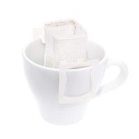 Drip bag coffee hanging on a coffee cup isolated on white background. photo