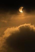 The Moon covering the Sun in a partial eclipse with dramatic cloud. Scientific background, astronomical phenomenon photo