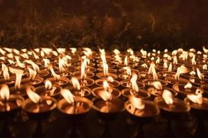 un suelo de velas encendidas que se encienden en el templo budista en Katmandú, Nepal. Encendiendo velas para orar y con propósito de fe. foto