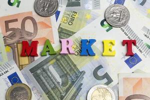 The word market is on the banknotes with coins. photo