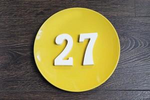 The number twenty-seven on the yellow plate. photo