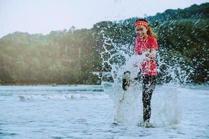 asian woman jogging workout on the beach in the morning. Relax with the beach. fun and happy with playing, jumping, kicking the sea. in summer photo