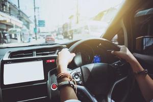 mano de mujer sosteniendo el volante de un coche. conducir un coche viajar relajarse en las vacaciones. habilidades de conducción un coche foto