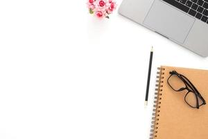 Creative flat lay photo of workspace desk. Top view office desk with laptop, glasses, pencil, notebook and plant on white color background. Top view with copy space, flat lay photography.