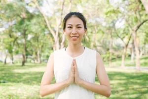 Young asian woman yoga outdoors keep calm and meditates while practicing yoga to explore the inner peace. Yoga and meditation have good benefits for health. Yoga Sport and Healthy lifestyle concept. photo